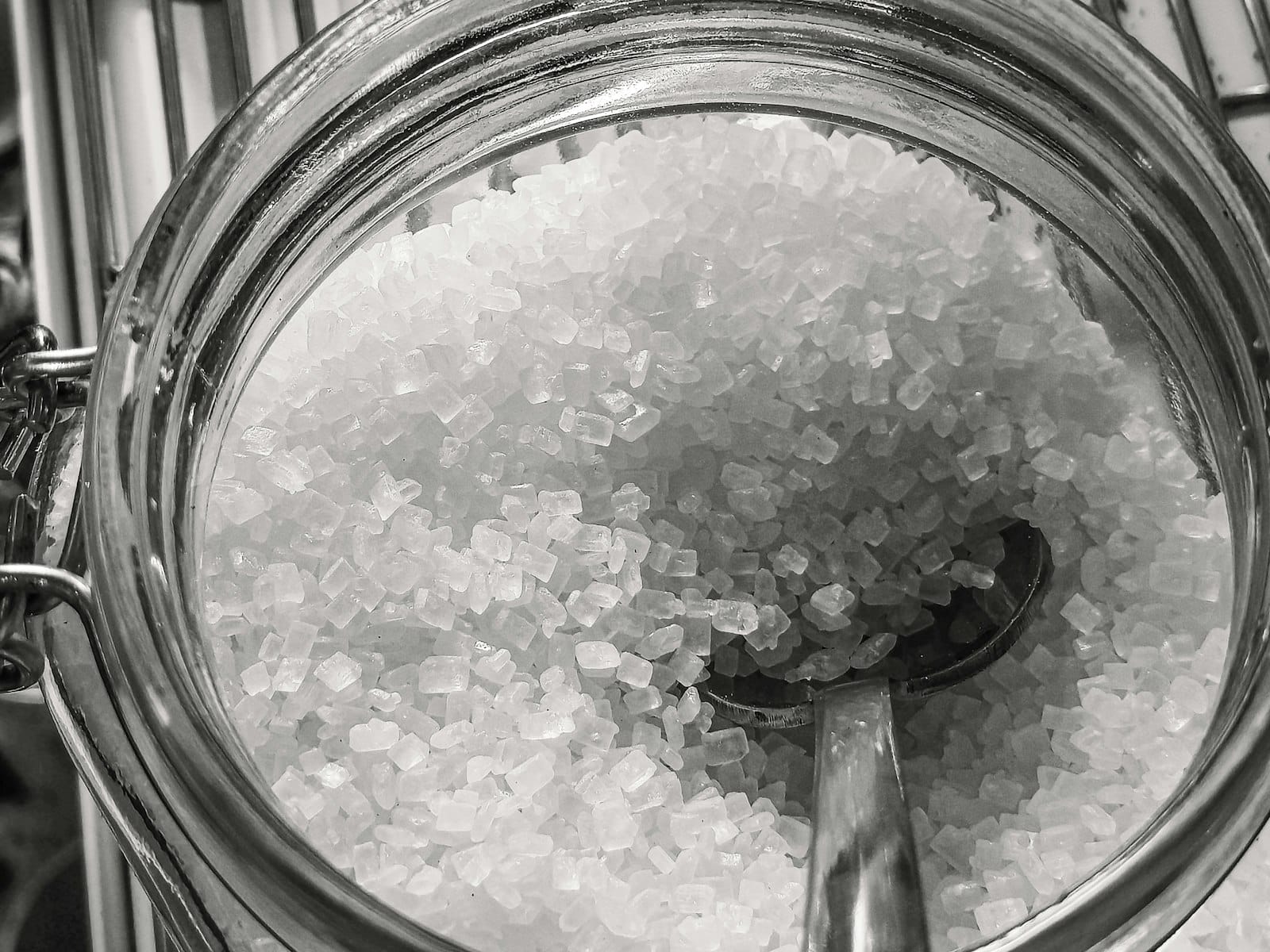 Coarse white salt crystals in close-up, the same plain sodium chloride sold as aquarium salt, without the iodine and anti-caking agents mixed into table salt.
